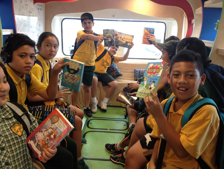 Children sitting in the bus reading books